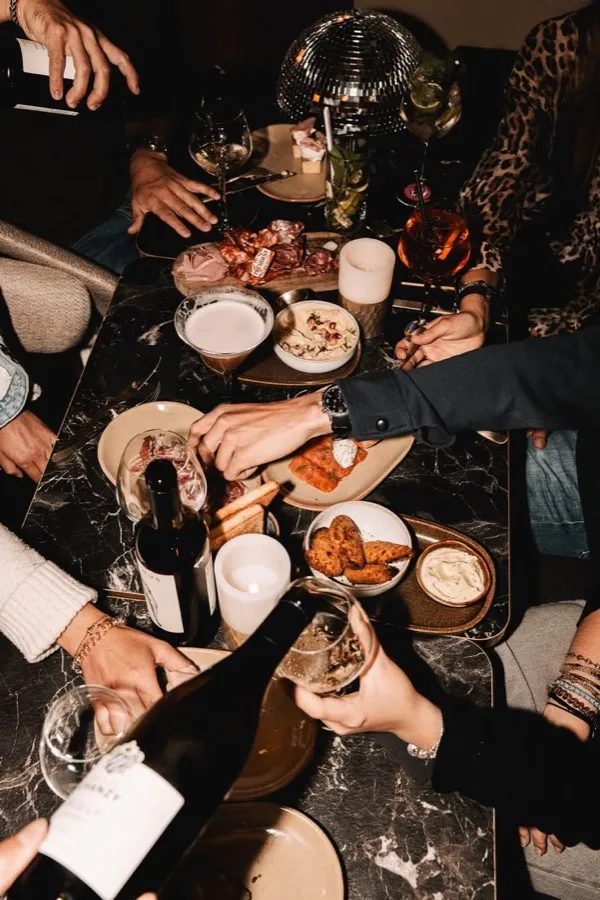 An overhead shot of a long dinner table mid-service.